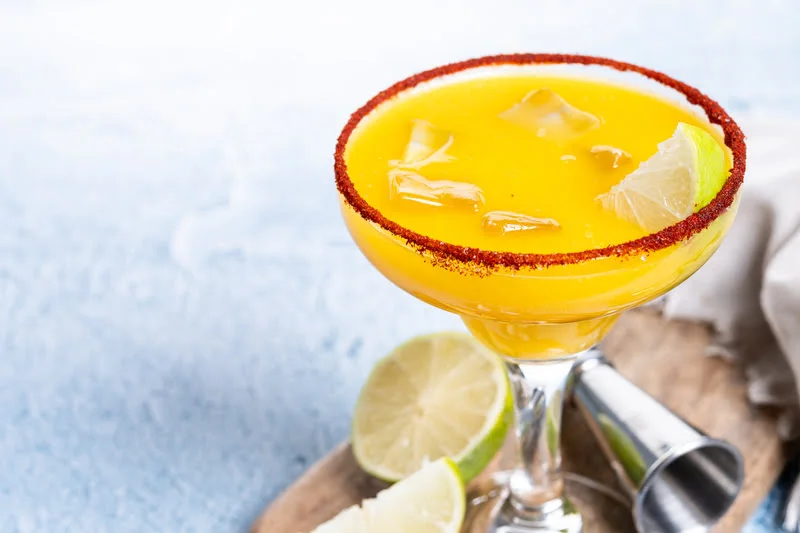 mango margarita with chili salt rim and lime garnish in a cocktail glass