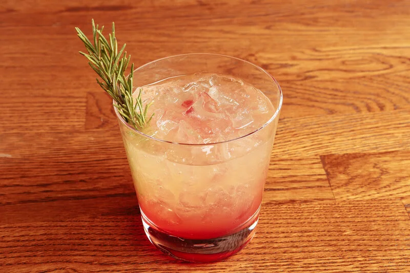 sparkling paloma cocktail with grapefruit soda and rosemary garnish