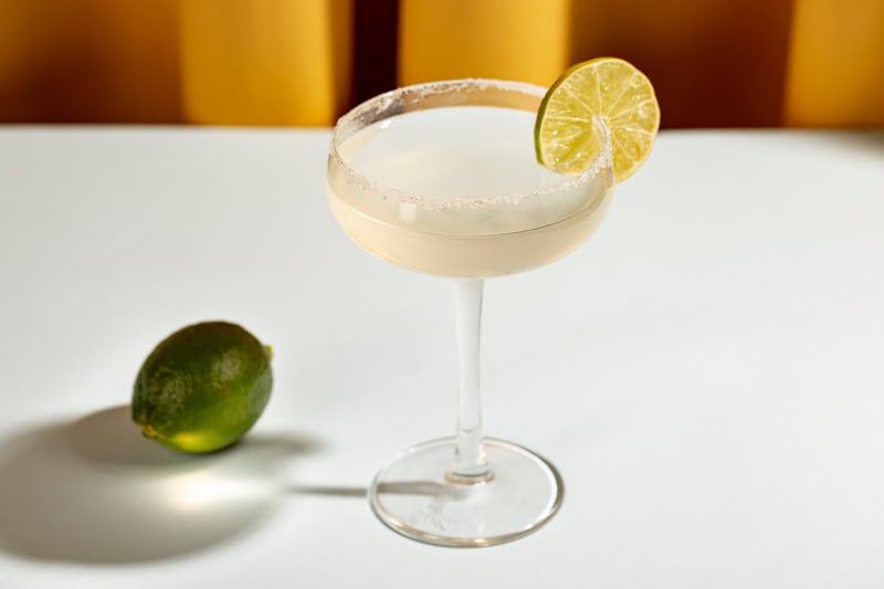 Champagne margarita cocktail with salted rim and fresh lime garnish