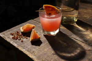spicy paloma cocktail with grapefruit garnish on wooden table