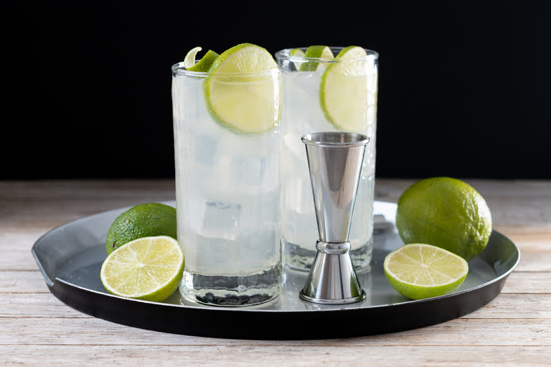 Cóctel Tequila Slammer con lima Dos cócteles Tequila Slammer con rodajas de lima servidos en vasos altos