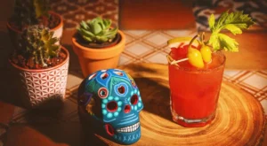 mexican bloody mary cocktail with garnish and skull decoration on table