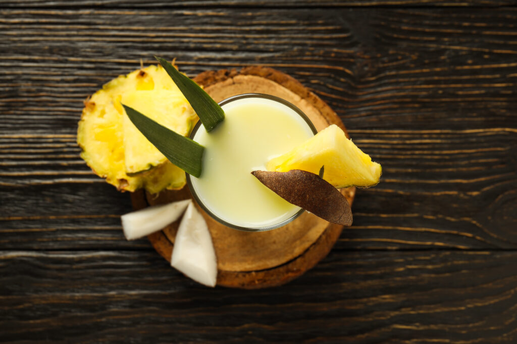 Ingredientes para un cóctel de tequila de piña: trozos de piña fresca y tequila Olmeca Altos listos para mezclarse en un vaso.